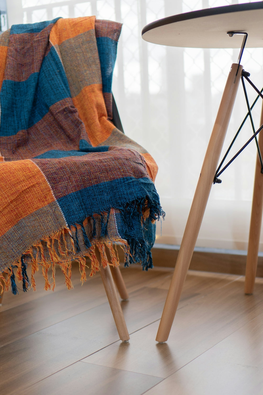 A chair with a blanket on it next to a table
